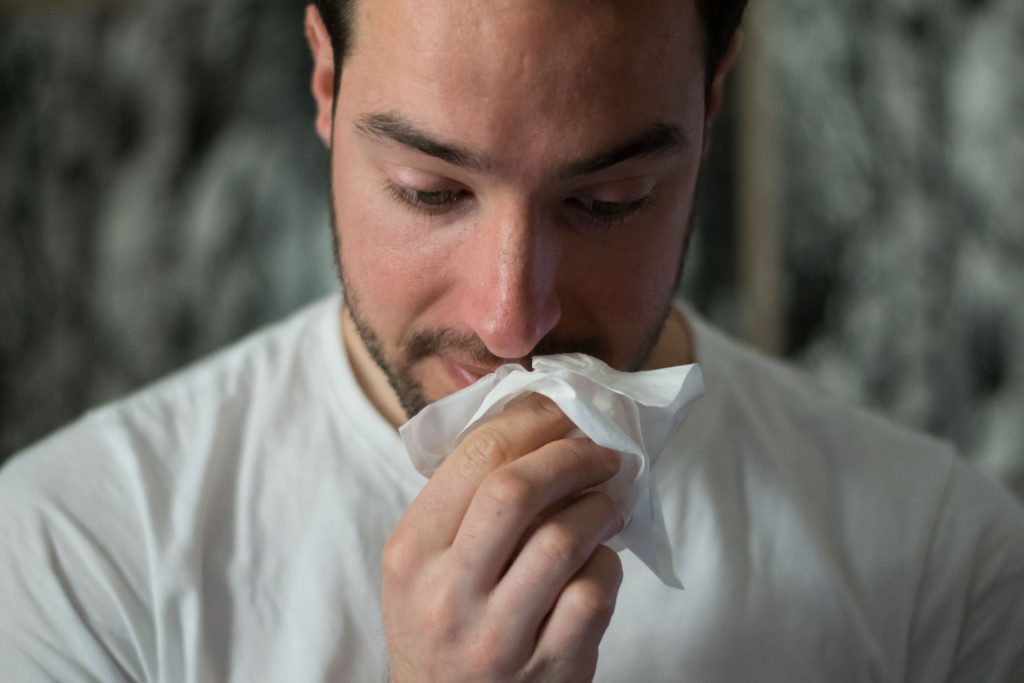 man wiping mouth with tissue paper