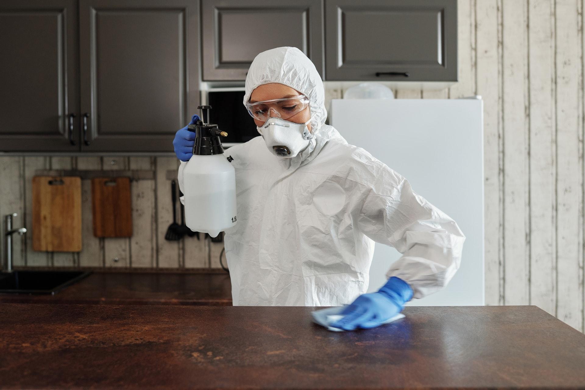 photo of person disinfecting table with liquid chemical.jpg